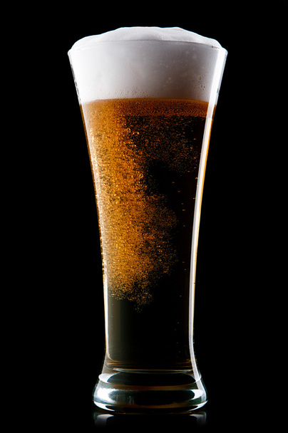 Beer into glass on a black - Foto, afbeelding