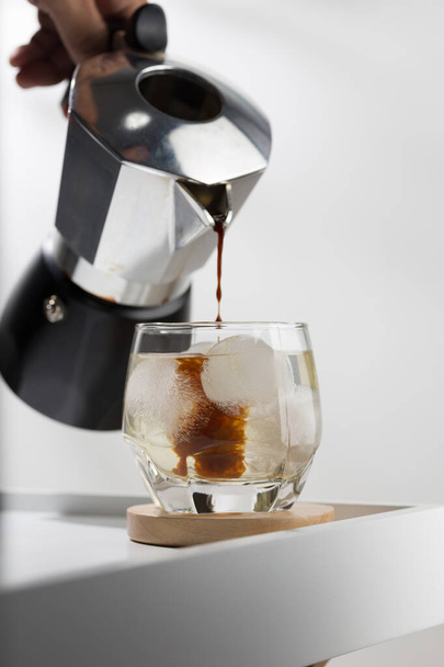 Den Espresso in kaltes Wasser gießen. americano brauen mit Moka-Topf. - Foto, Bild