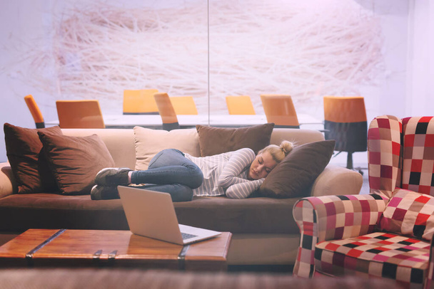 vrouw slapen op een bank in een creatieve kantoor - Foto, afbeelding