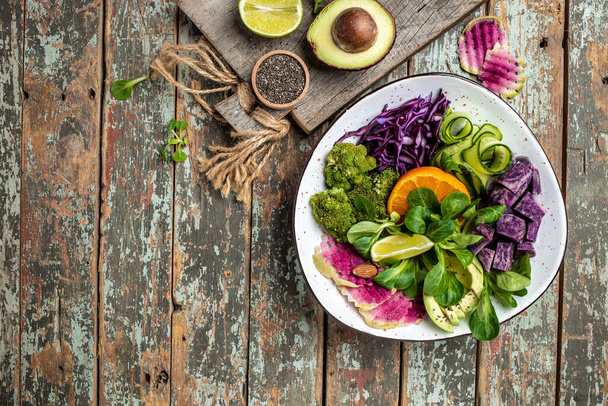 Zdravý vegetariánský miskový veganský salát se sladkými brambory, brokolicí, avokádem, fialovým zelím, okurkou, ředkvičkou a mandlemi. Čisté stravování, dietní stravování. pohled shora. - Fotografie, Obrázek