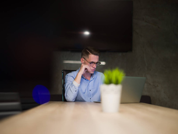 homme travaillant sur ordinateur portable dans le bureau sombre
 - Photo, image