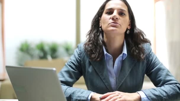 Businesswoman talking to camera in the office - Video, Çekim