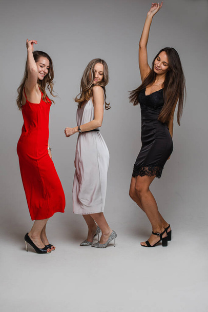 "three cheerful female friends in beautiful dresses" - Zdjęcie, obraz