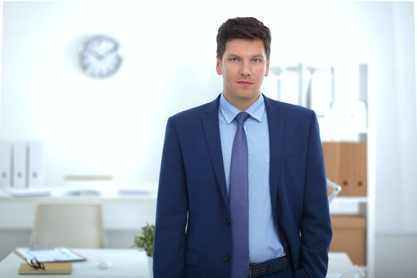 Udanego biznesu młody człowiek stoi w biurze - Zdjęcie, obraz