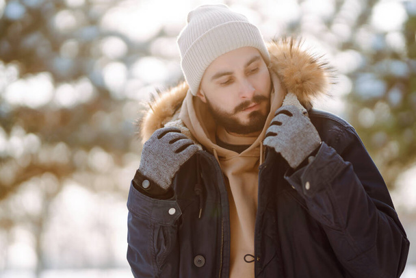 Bearded man smiling at camera in winter park. Season, christmas, travel and people concept. - Fotó, kép