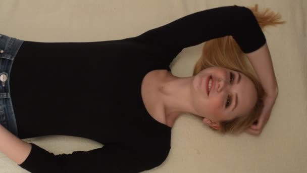 νεαρή ξανθιά γυναίκα στο κρεβάτι - Πλάνα, βίντεο