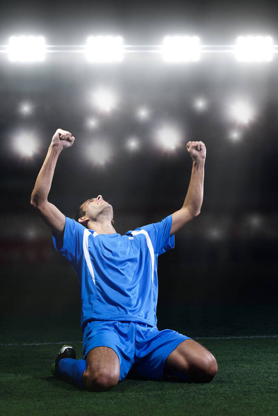 voetbalspeler voor het grote moderne stadion met fakkels en lichten - Foto, afbeelding