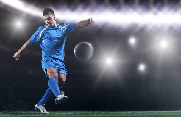 joueur de football en face du grand stade moderne avec des fusées éclairantes et des lumières - Photo, image