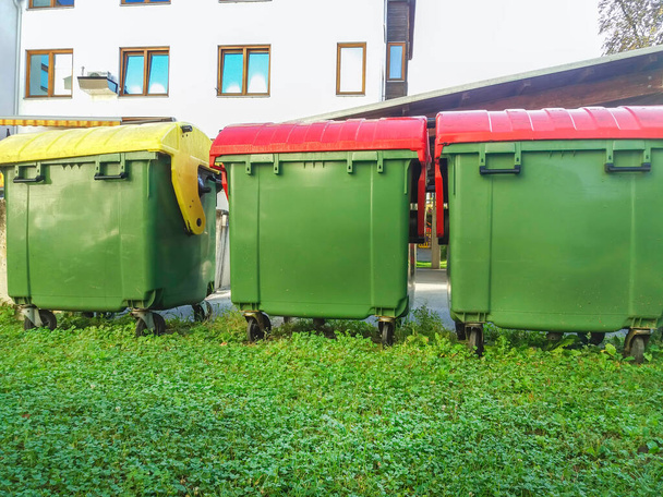Cubos de basura en diferentes colores para la gestión de residuos, papeleras de reciclaje en la calle - Foto, imagen