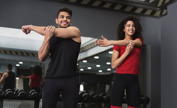 Healthy multiracial athletes exercising at gym together - Photo, Image