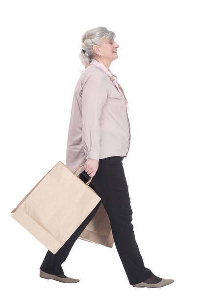 glimlachende oude dame met boodschappentassen die naar voren glijden - Foto, afbeelding