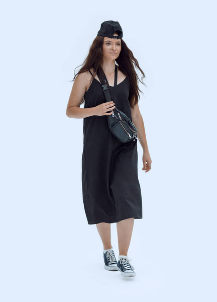 σε πλήρη ανάπτυξη. κομψή γυναίκα σε μαύρο ντύσιμο περπάτημα προς τα εμπρός. - Φωτογραφία, εικόνα
