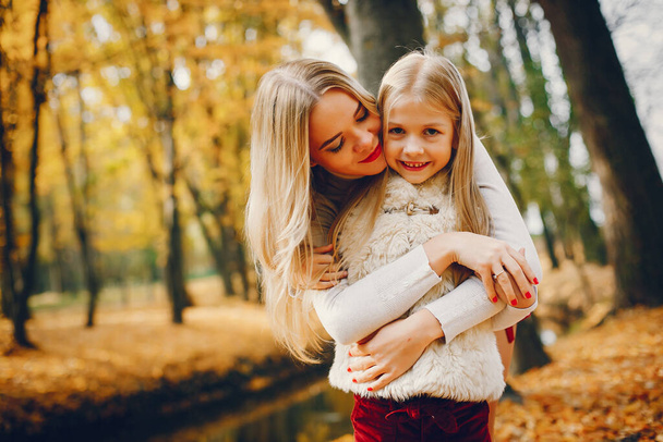 Fashionable mother with daughter. Family in a autumn park. - Valokuva, kuva