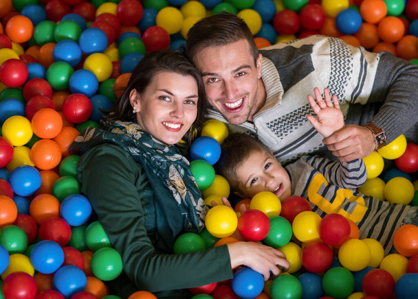 parents and kids playing in the pool with colorful balls - Фото, изображение