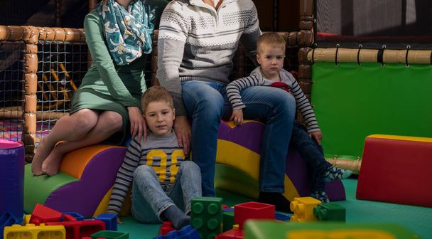 padres jóvenes y niños divirtiéndose en la sala de juegos para niños - Foto, Imagen