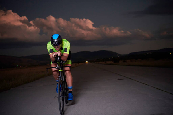 triathlon athlete riding bike fast  at night - Fotoğraf, Görsel