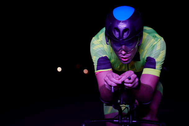 夜は速く自転車に乗るトライアスロン選手 - 写真・画像