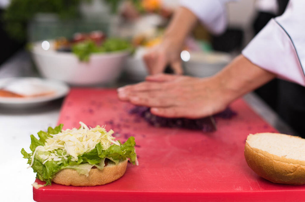 "chef hands cutting salad for burger" - Foto, Imagem