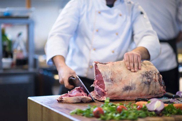 "chef cortando grande pedaço de carne
" - Foto, Imagem