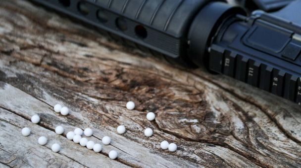 Gros plan balles en plastique de pistolet airsoft ou pistolet bb sur le sol en bois, accent doux et sélectif sur les balles - Photo, image