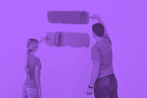 giovane coppia pittura muro a nuova casa - Foto, immagini