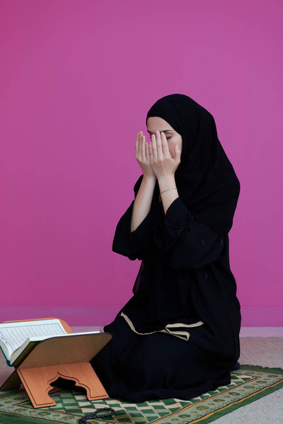中東の女性は聖クルアーンを祈り読みます - 写真・画像