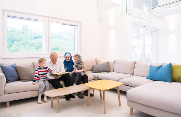 abuelos musulmanes modernos con nietos leyendo el Corán
 - Foto, Imagen