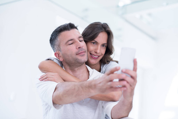 "Счастливая пара с помощью мобильного телефона дома" - Фото, изображение
