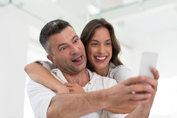"happy couple using mobile phone at home" - Photo, Image
