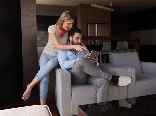 "пара розслабляється вдома з планшетними комп'ютерами
" - Фото, зображення