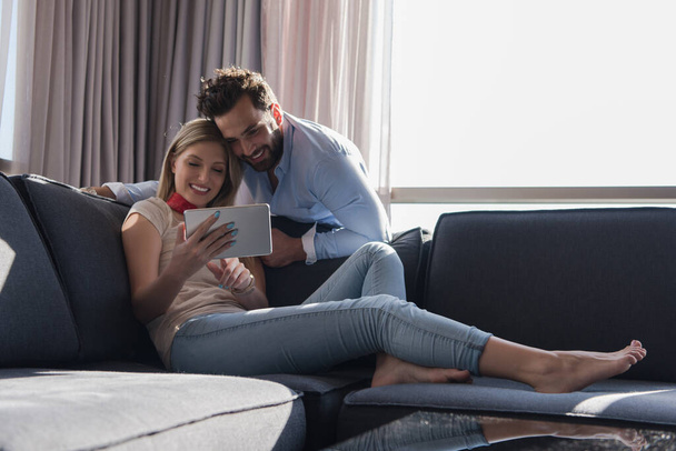 "coppia rilassante a casa utilizzando tablet
" - Foto, immagini