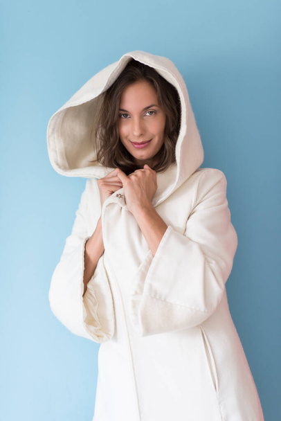 "femme dans un manteau blanc avec capuche sur fond bleu" - Photo, image