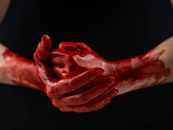 "Жіночі кулаки в крові на чорному тлі. Кулак і долоня
." - Фото, зображення