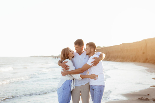 Happy middle-aged family with an adult son by the sea. Lifestyle concept. Close-up photo. - Photo, Image