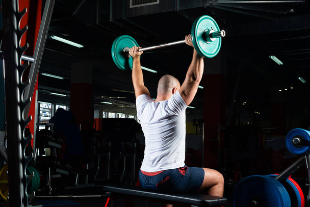"Male athlete lifts the barbell" - Фото, зображення