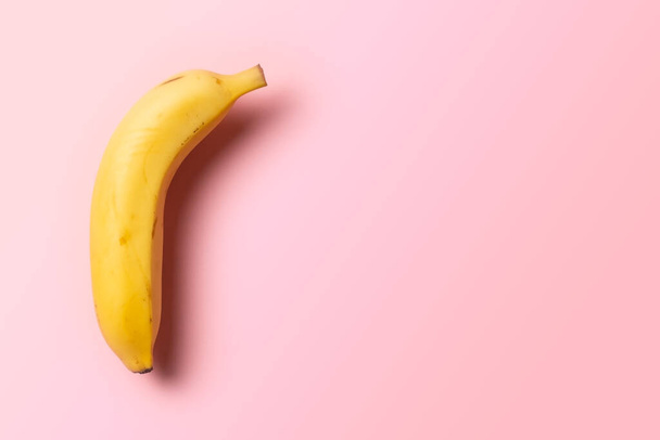 a single banana on a pink background - Foto, imagen