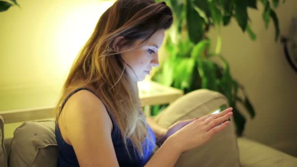 Žena surfování čisté v tabletovém počítači doma na pohovce - Záběry, video