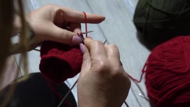 Vrouw handen breien sok met naalden en garen van rode kleur. Sluiten van de handen - Video