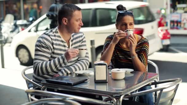 Happy couple talking in outdoor city cafe - Materiał filmowy, wideo