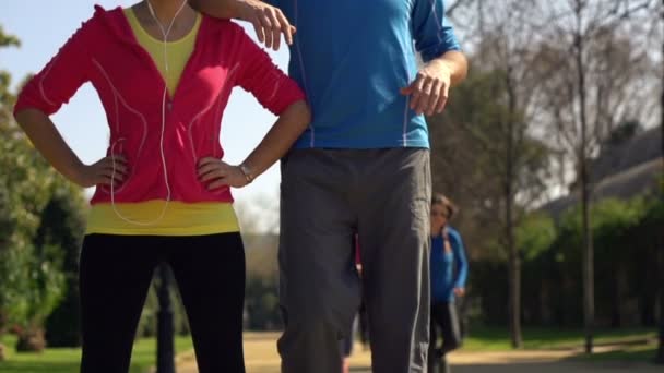 Happy joggers, couple standing in park - Video, Çekim
