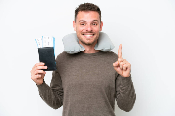Young caucasian man holding a passport isolated on white background pointing up a great idea - Φωτογραφία, εικόνα