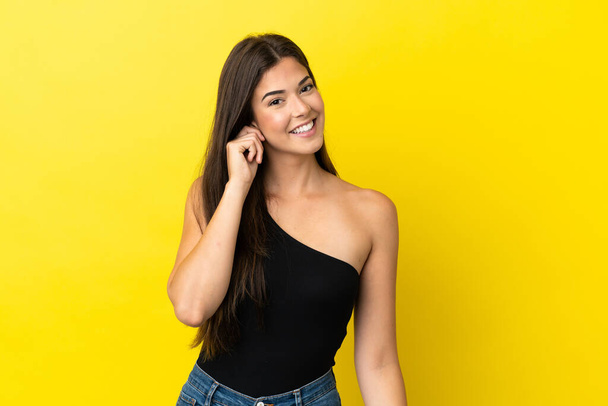 Young Brazilian woman isolated on yellow background laughing - Фото, зображення