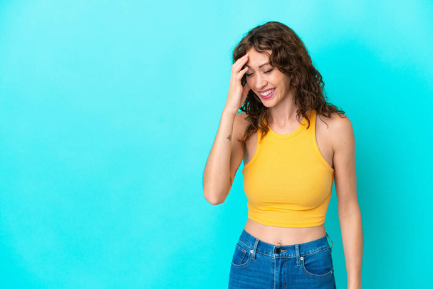 Young woman with curly hair isolated on blue background laughing - Photo, Image