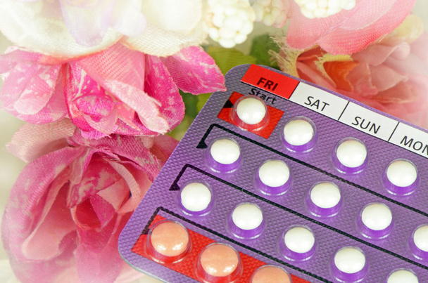 28 tablet antikoncepční pilulky s dnem označené v den zahájení s jemnou květinovou pozadím. - Fotografie, Obrázek
