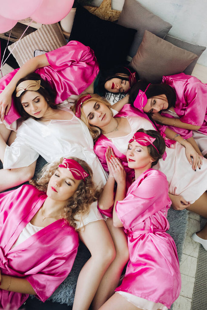 Αστείες φιλενάδες με ροζ ρόμπες με μέλλουσα νύφη. - Φωτογραφία, εικόνα