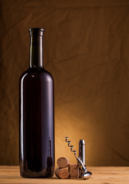 Wine bottle and corkscrew on table - 写真・画像