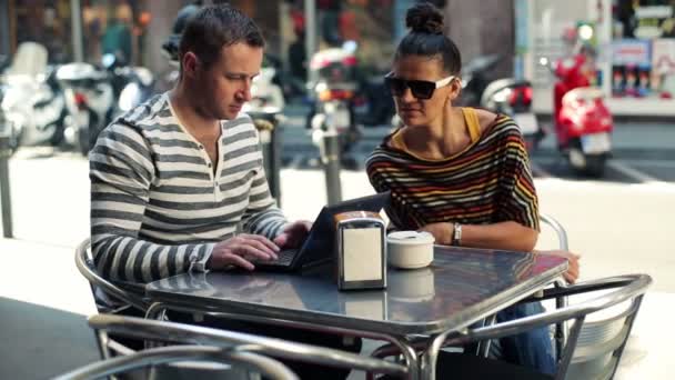 Casal jovem falando sobre laptop moderno no café
 - Filmagem, Vídeo