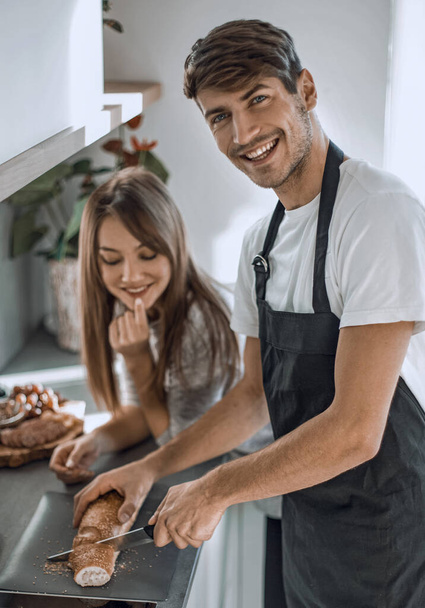 "счастливая молодая пара с едой на новой кухне - Фото, изображение