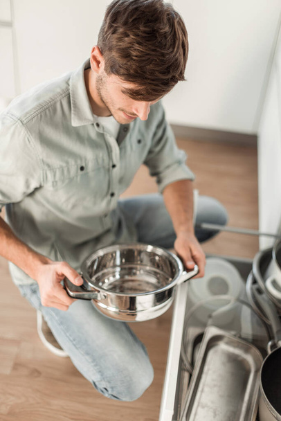 "食器洗い機できれいな料理を見ている若者は" - 写真・画像