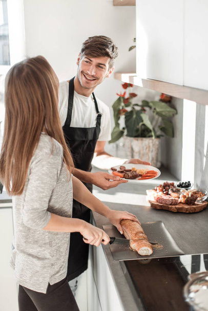 "happy young couple with food in their new kitchen - Foto, Bild